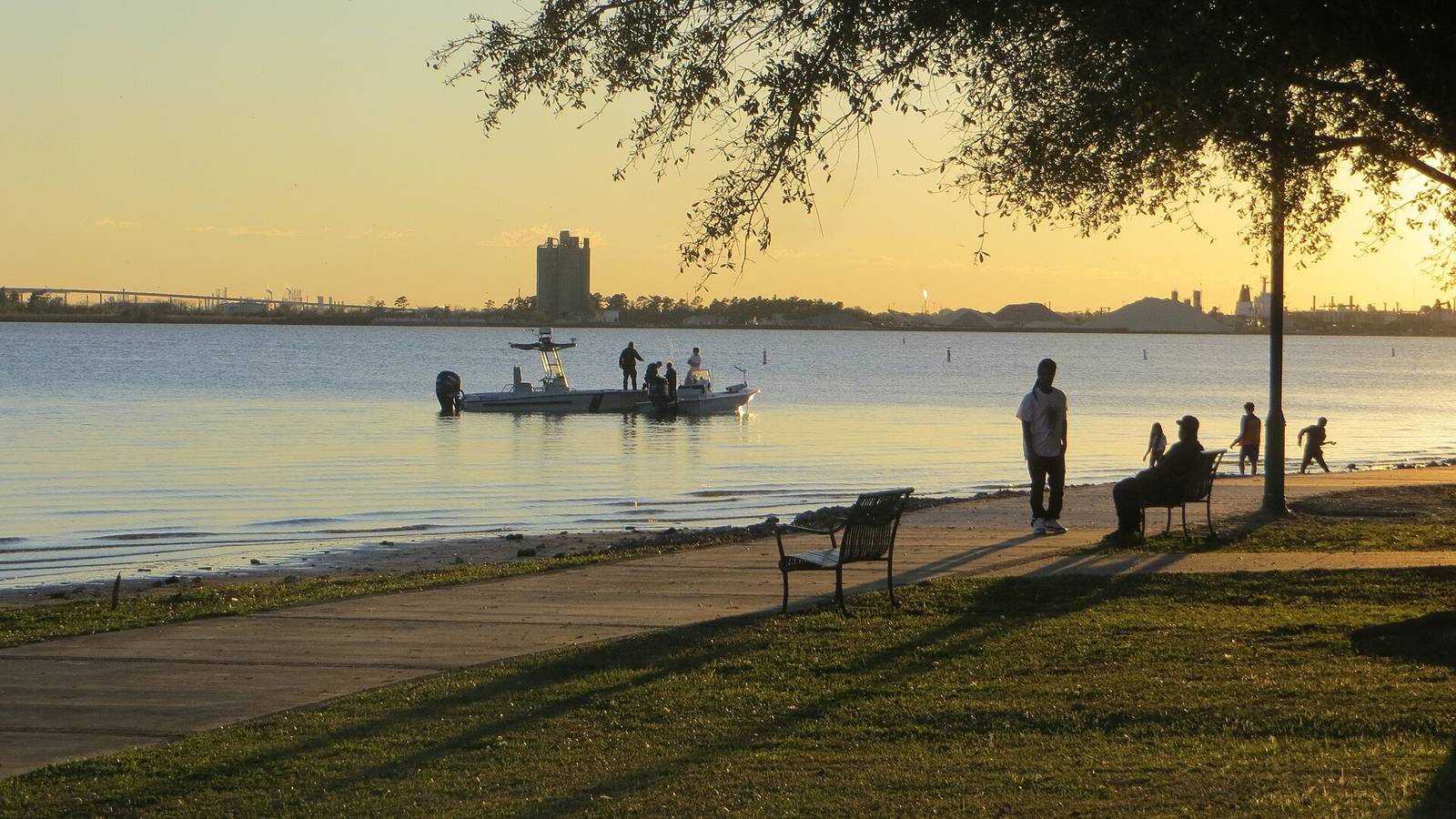 The Lake Charles lakefront at sunset, with the city skyline across the water